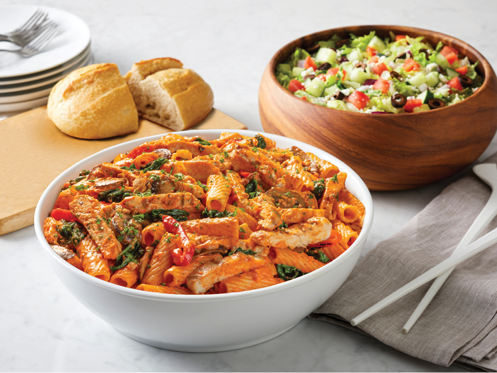 A large bowl of Pasta Brio with a side salad and bread